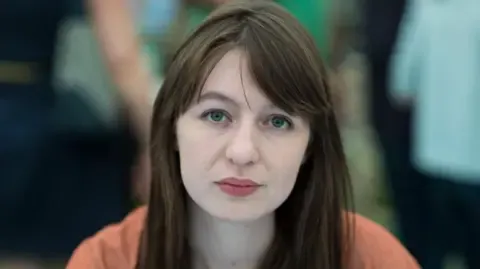 The acclaimed novelist claims she is unable to enter the UK due to arrest fears